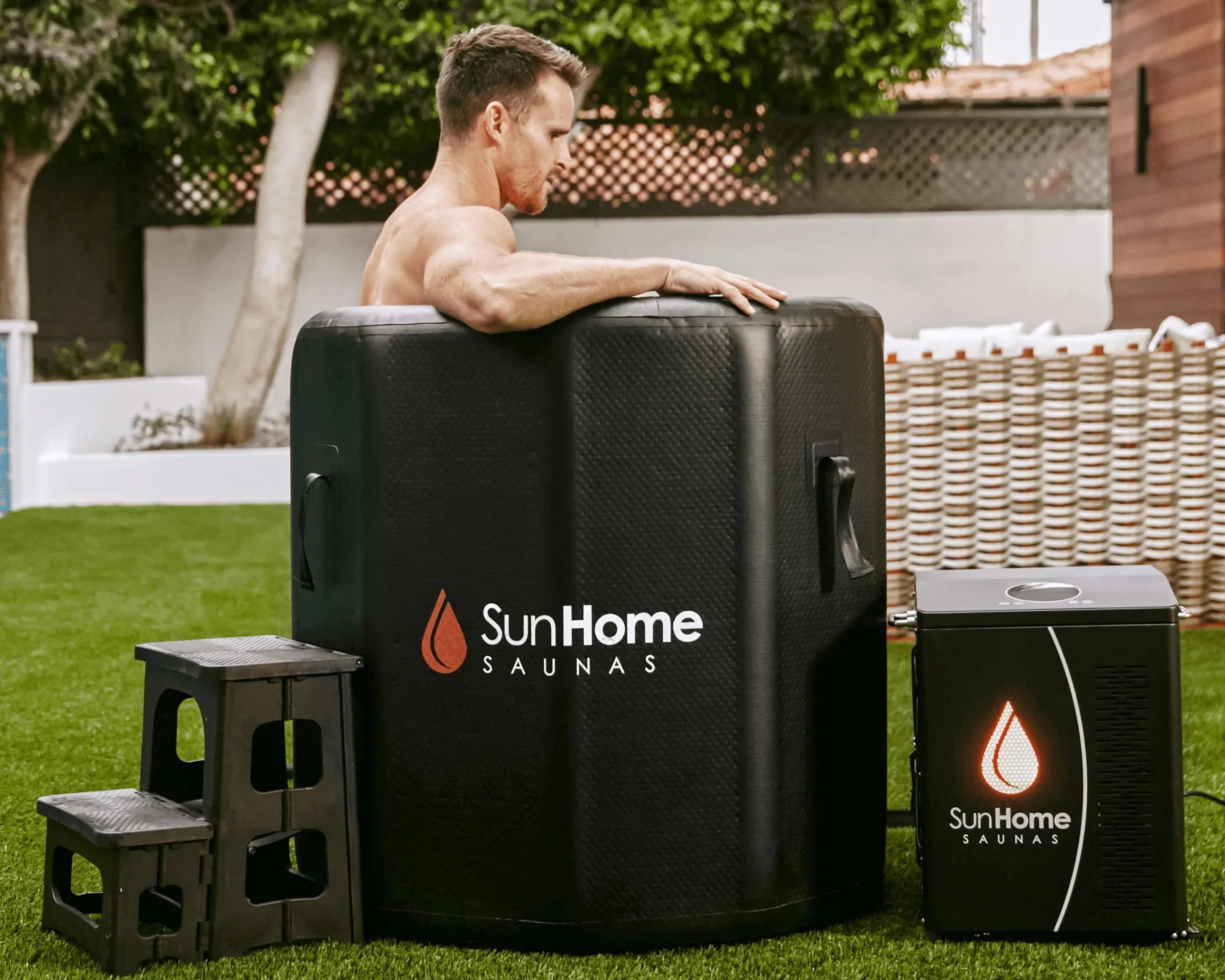 Man resting on the rim of the Sun Home Cold Plunge Vertical beside its chiller